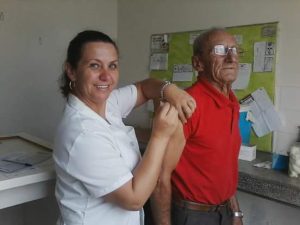 Auxiliar de enfermagem Sinerley aplica vacina em morador